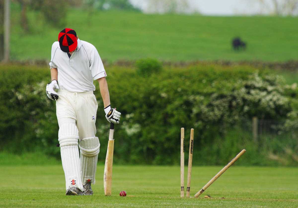 A cricketer standing next to the
stumps